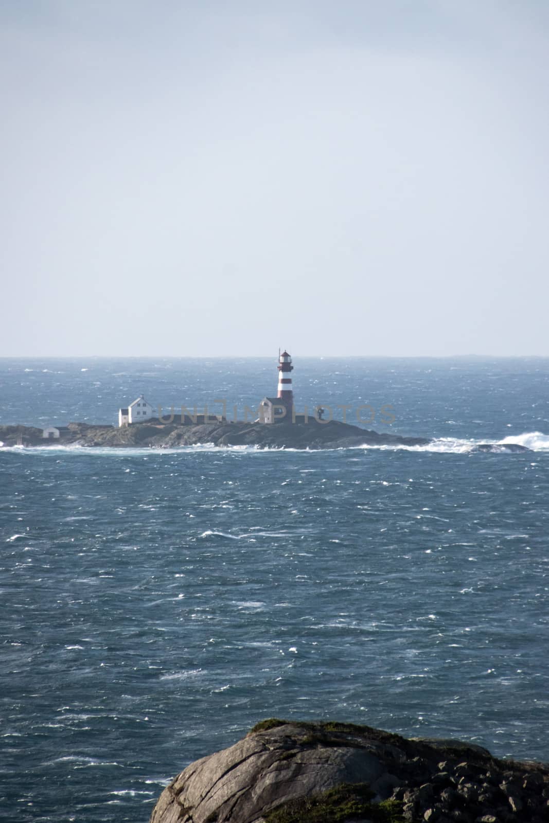 Lighthouse in winter storm Atlantic ocean by MXW_Stock