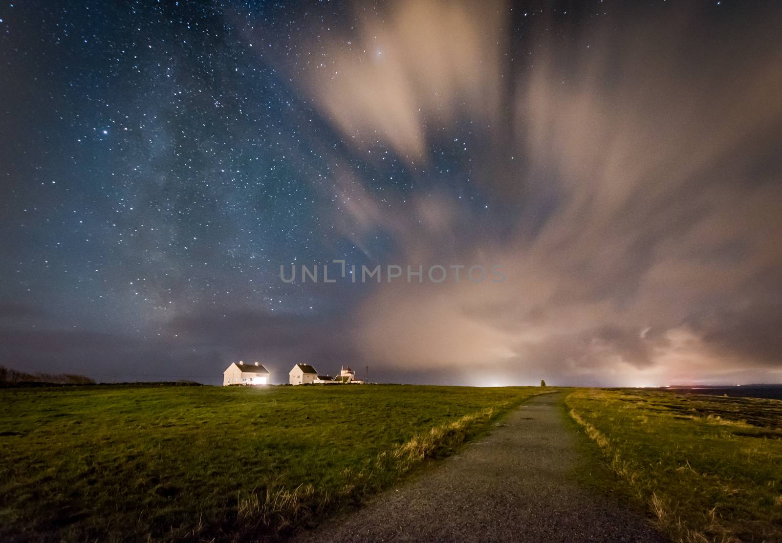 Milky way behind clouds over farm Norway