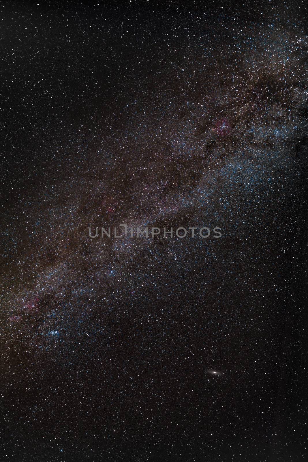 Center of milky way in night sky with red nebulas and andromeda galaxy by MXW_Stock