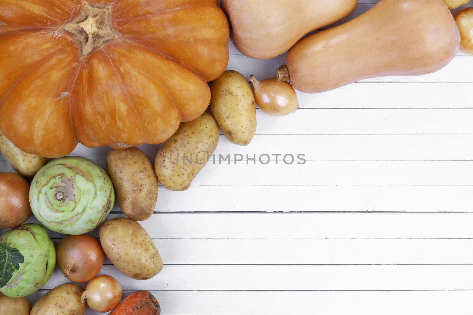 Autumn vegetables on white wooden table background, top view by xamtiw