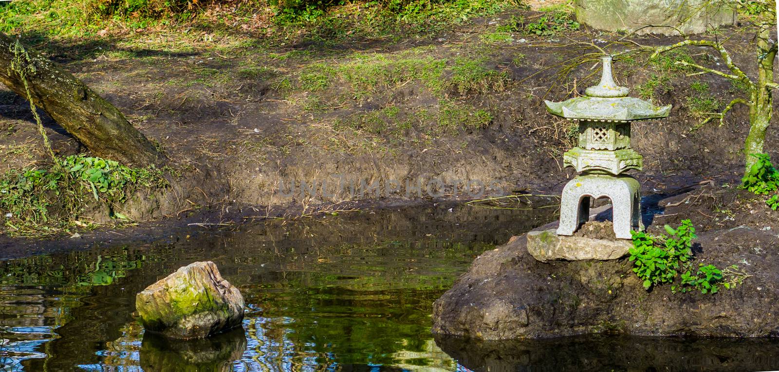 Water pond in a japanese garden with a tower sculpture, Asian garden background by charlottebleijenberg