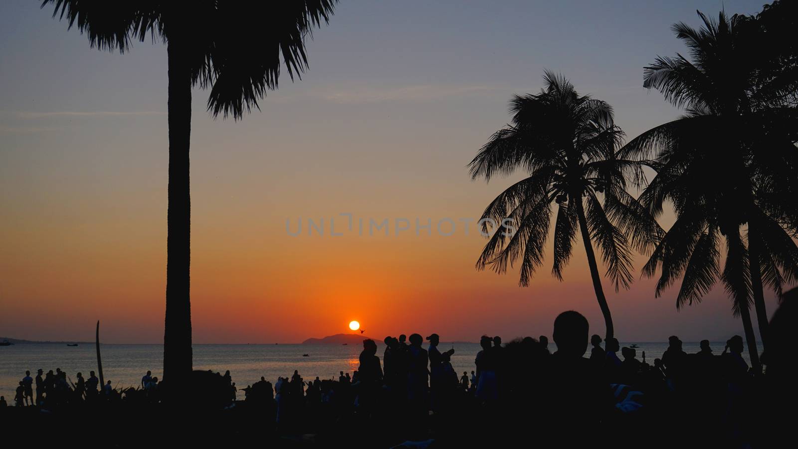 Silhouetted People Relaxing on Sunset Beach by natali_brill