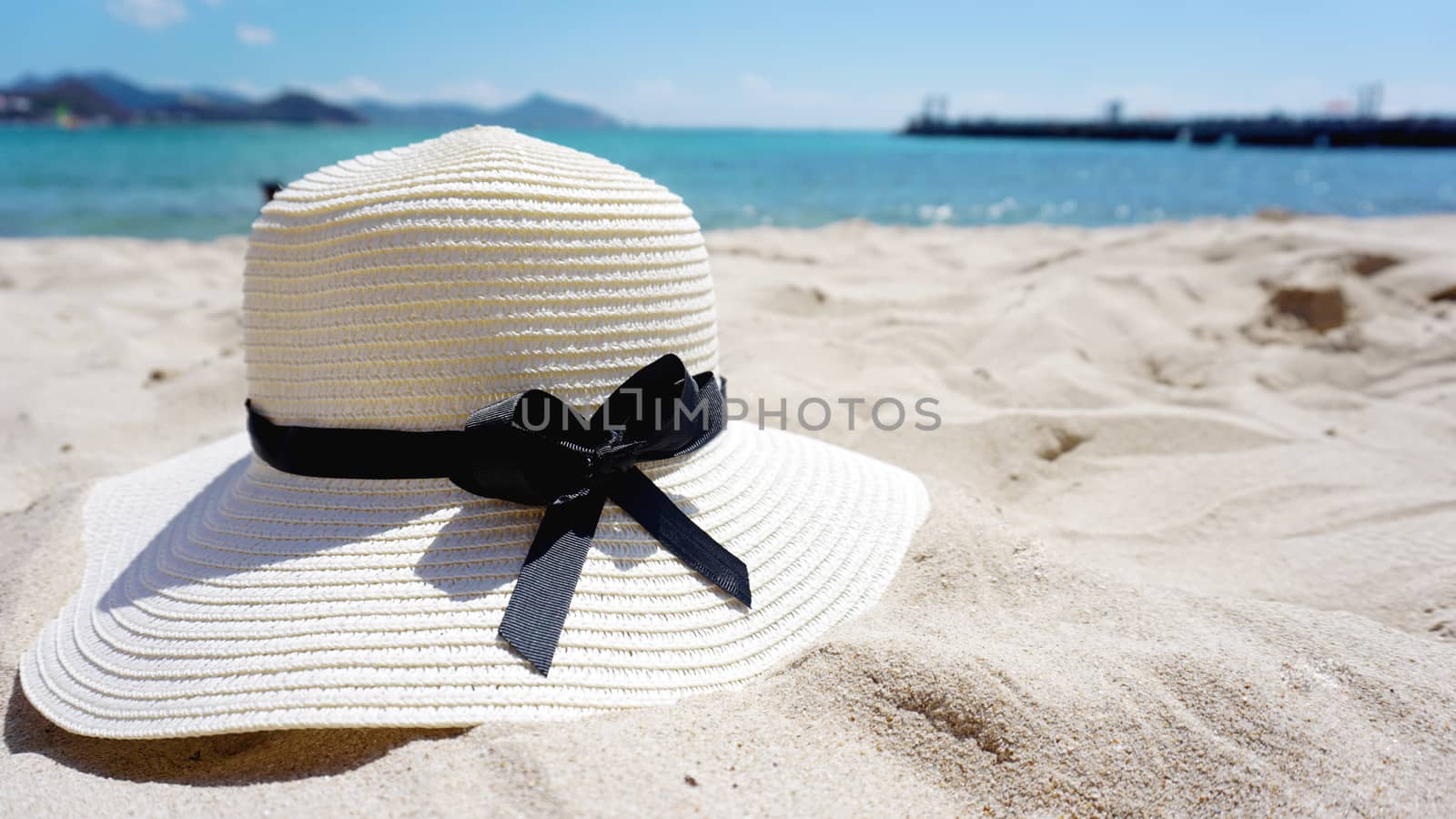 Beautiful Tropical Beach blue ocean background with a hat on the yellow sand by natali_brill