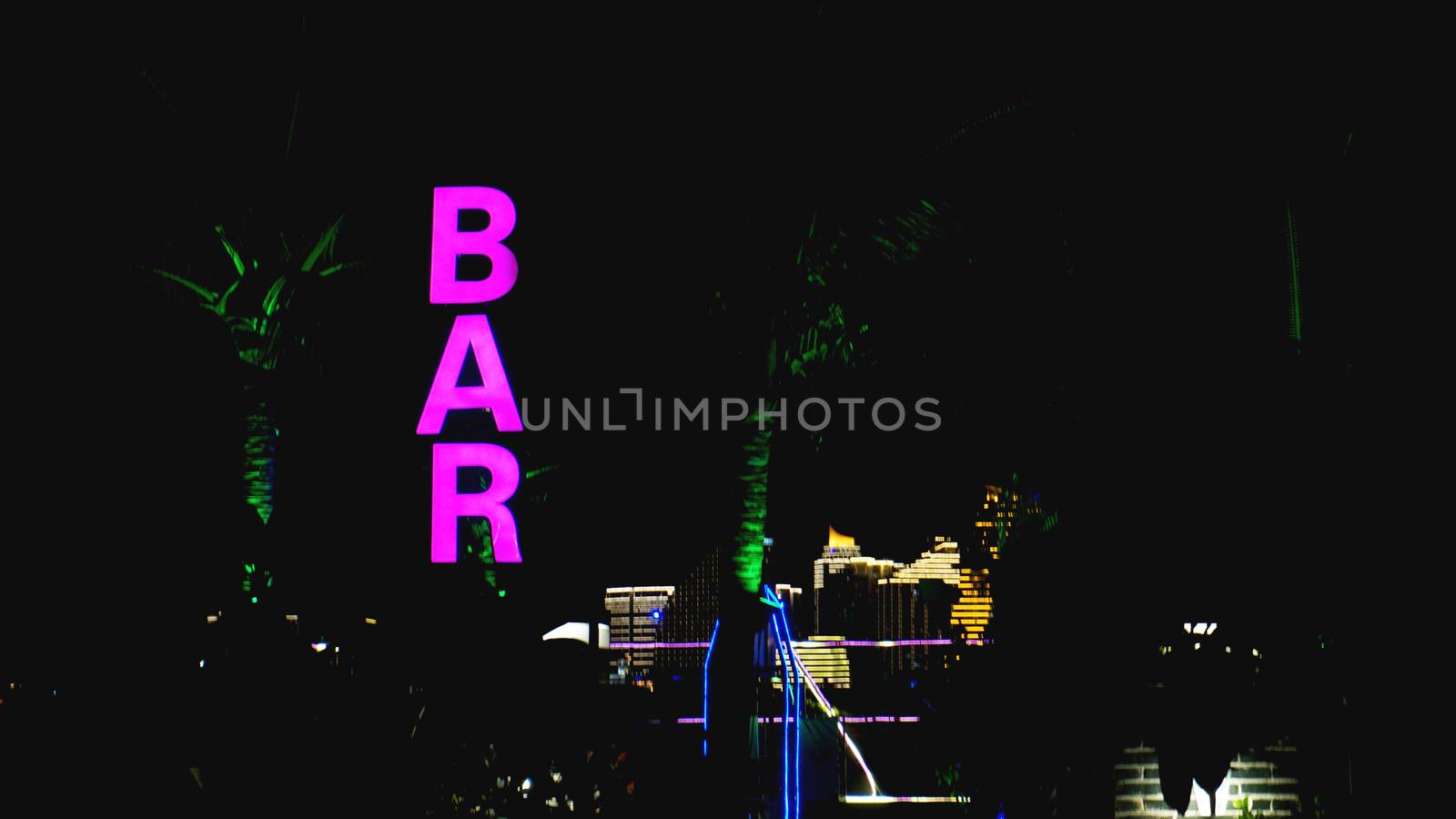 Pink neon sign of the word Bar on a black background.