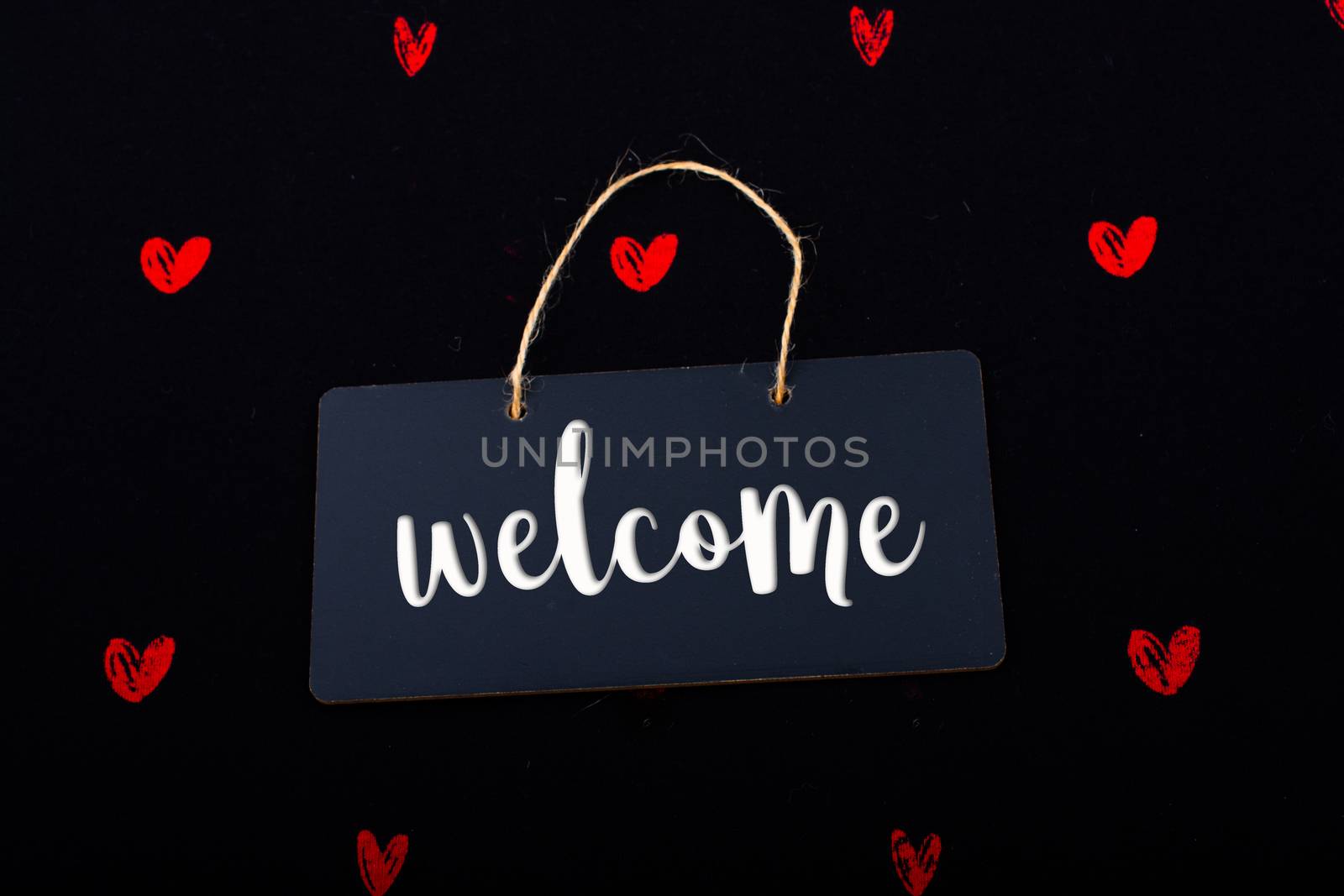 Welcome wording on black notice board  with red hearts around