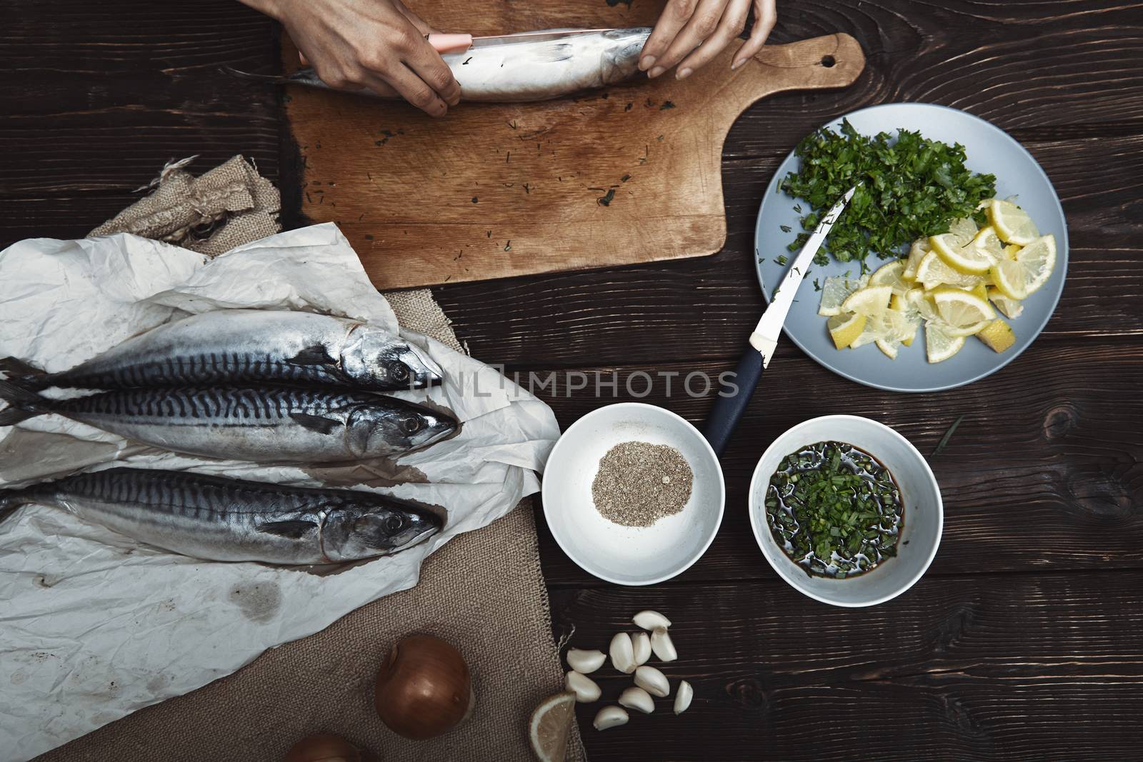 Woman preparing mackerel fish by Novic