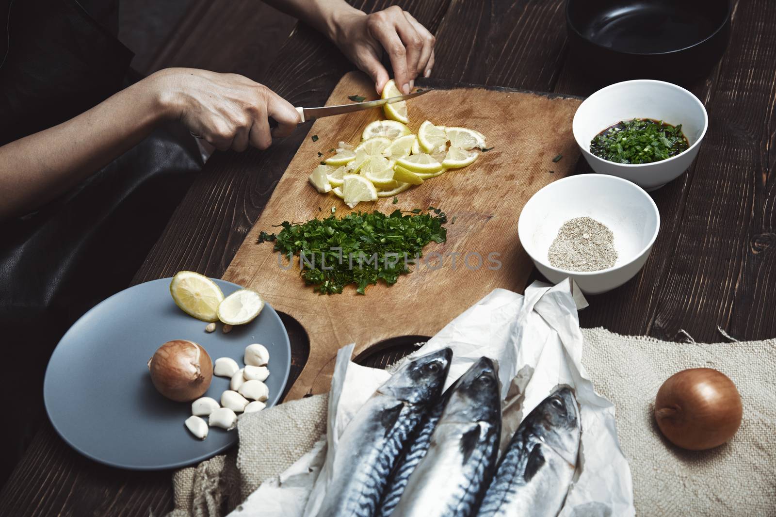 Woman cutting lemon for fish stuffing