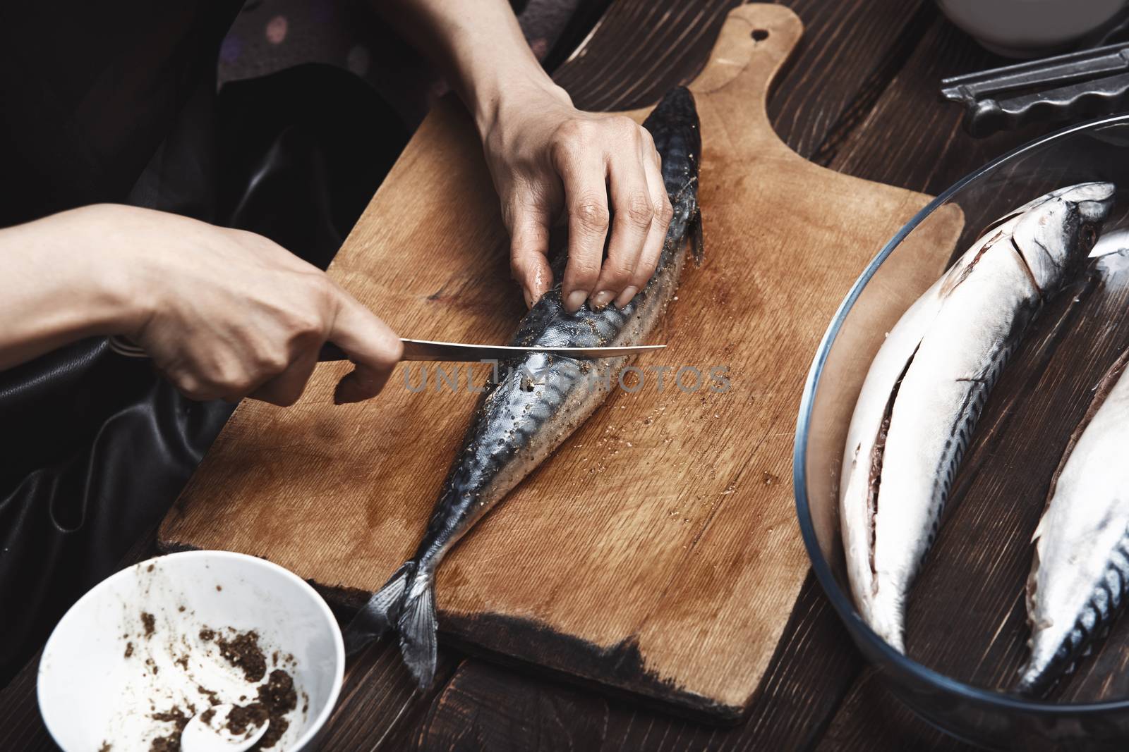 Woman preparing mackerel fish by Novic