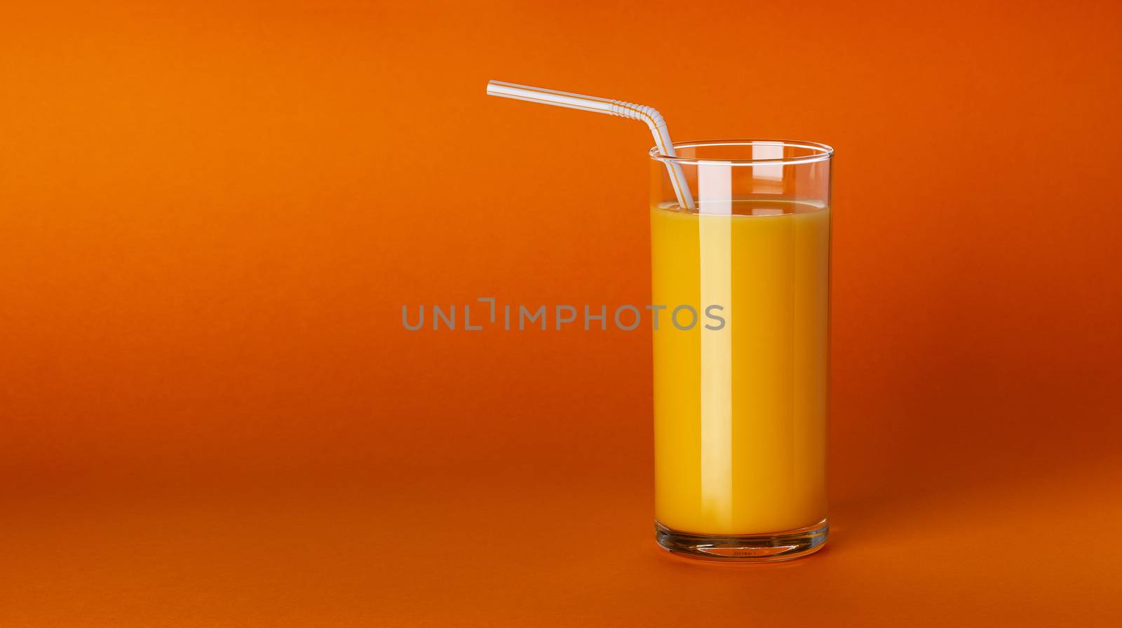 A glass of orange juice on orange background with copy space by xamtiw