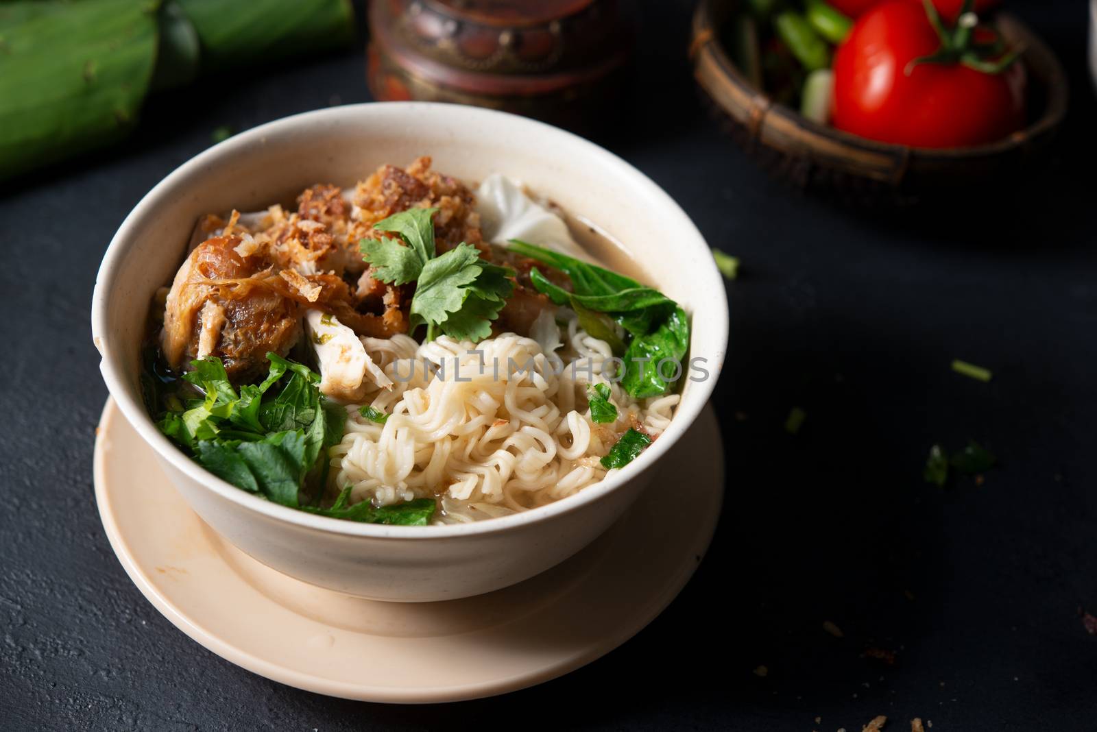 Asian ramen noodles soup and chicken in bowl on dark background. 