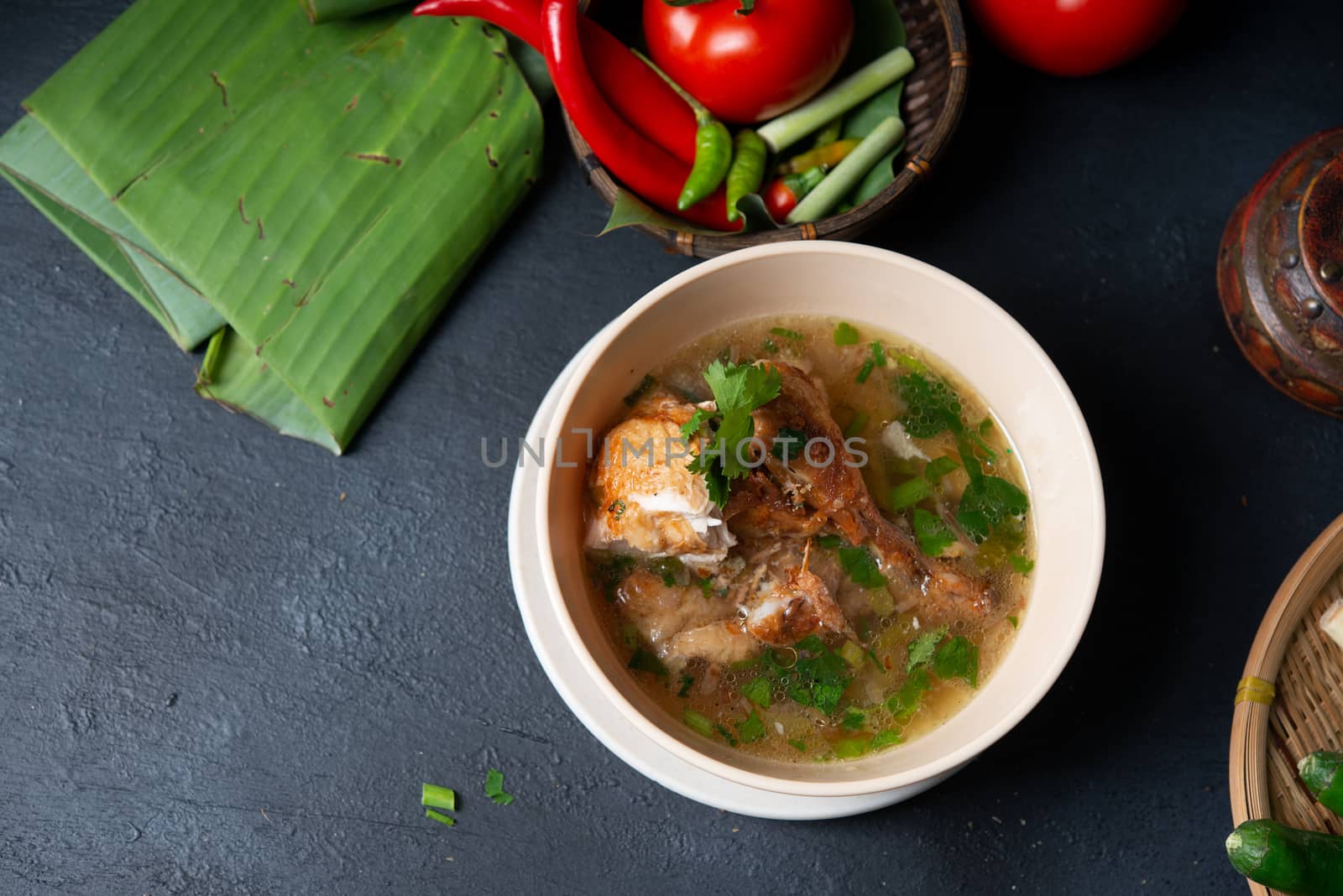 Asian style chicken soup in bowl, dark background. Top view flat lay with copy space.