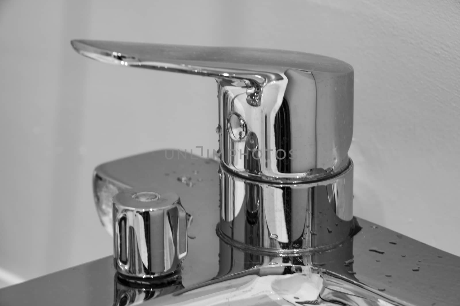 Modern faucet of chrome color in bathroom interior
