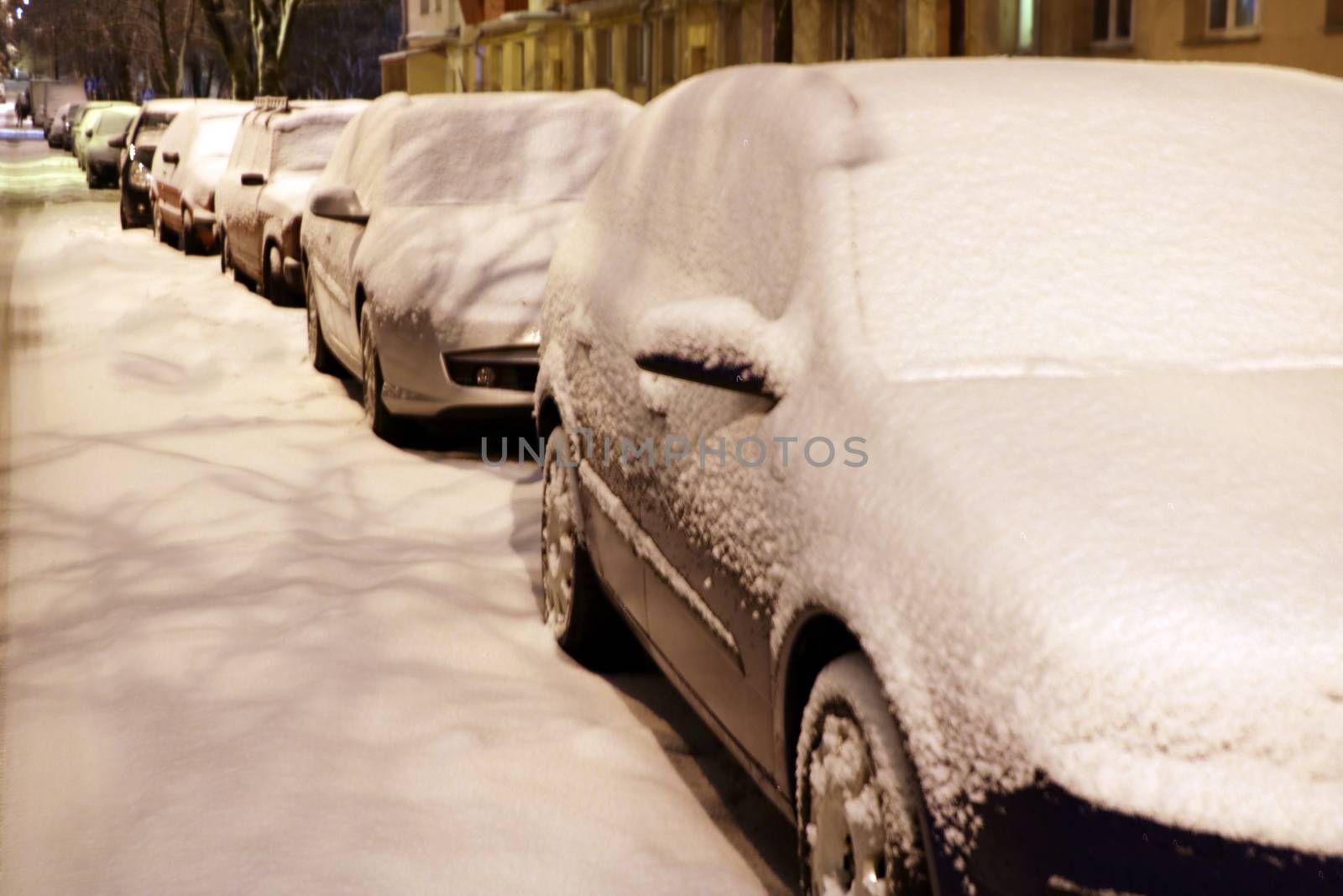 Cityscape - parked cars covered with snow. Winter