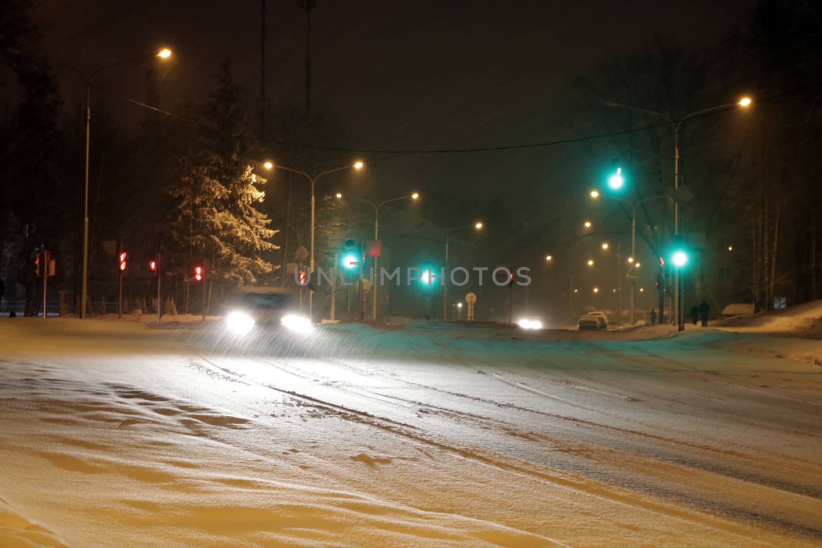Snowy winter road with cars driving on roadway in snow storm