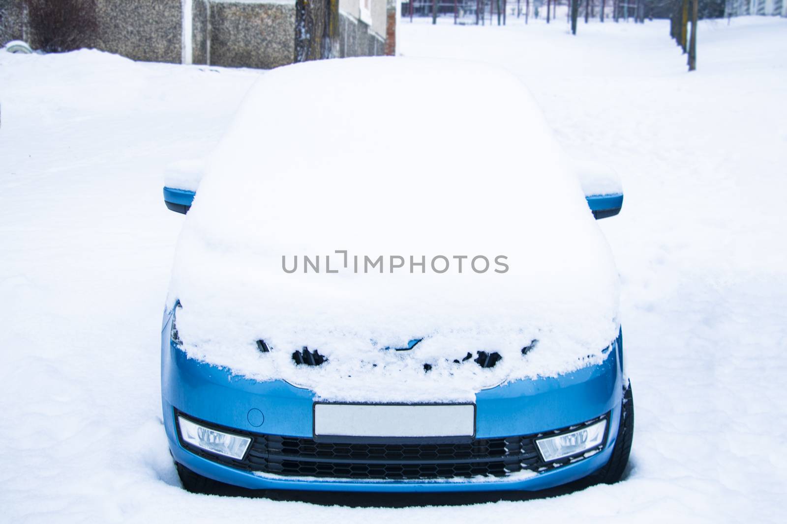 Frozen car covered snow at winter day, view front window windshield and hood on snowy background. by kip02kas