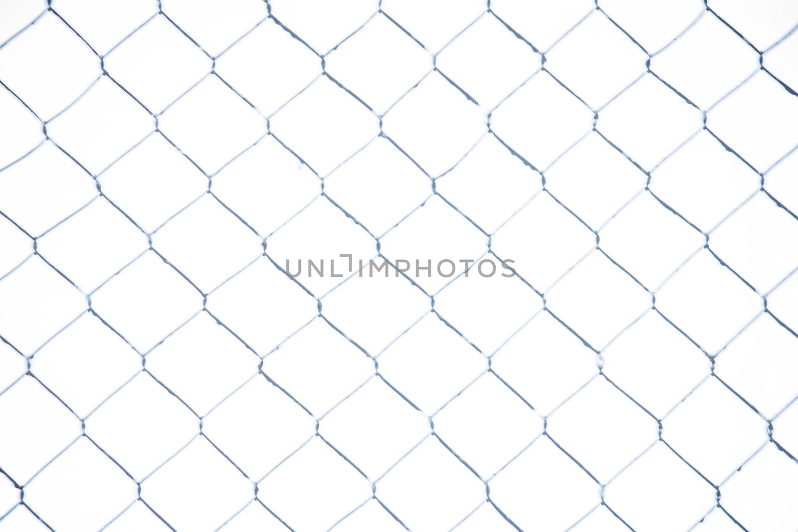 Wire fence in the snow. Fence background. Metallic net with snow. Metal net in winter covered with snow. Wire fence closeup. Steel wire mesh fence vintage effect
