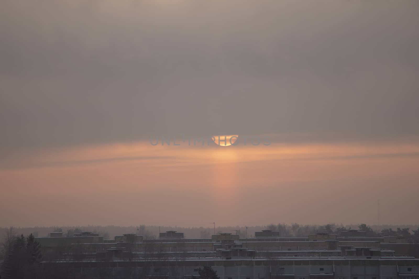 the sun rises over the city on a frosty day in winter