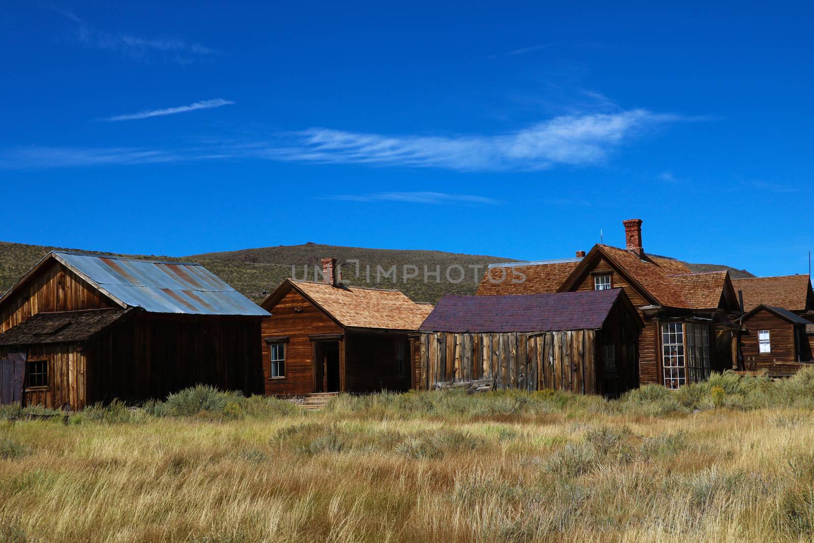 Colored vintage old looking photo of empty streets of abandoned ghost town Bodie in California, USA in the middle of a day.