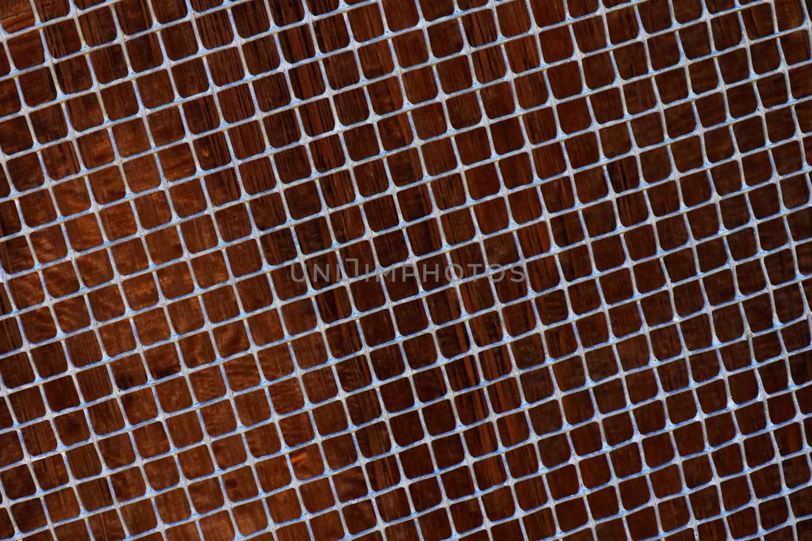 Old metal grid covered with rust and blured brown background