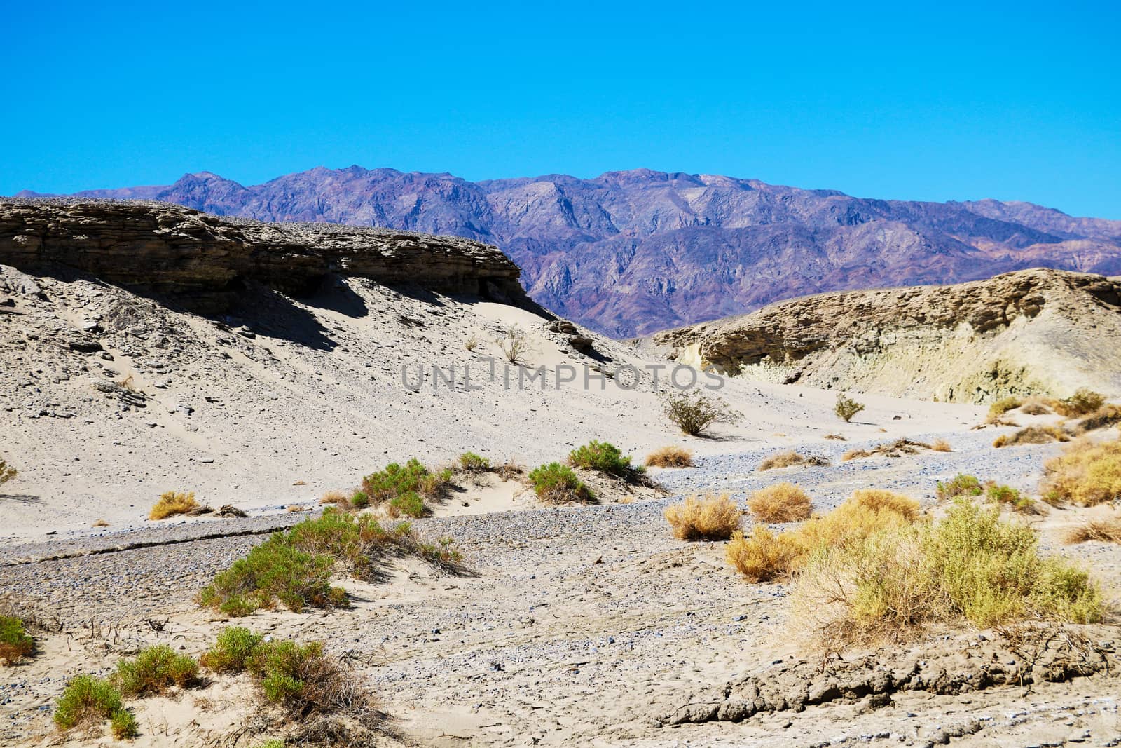 View of the dried mountain river in the background of mountains and sand. by kip02kas