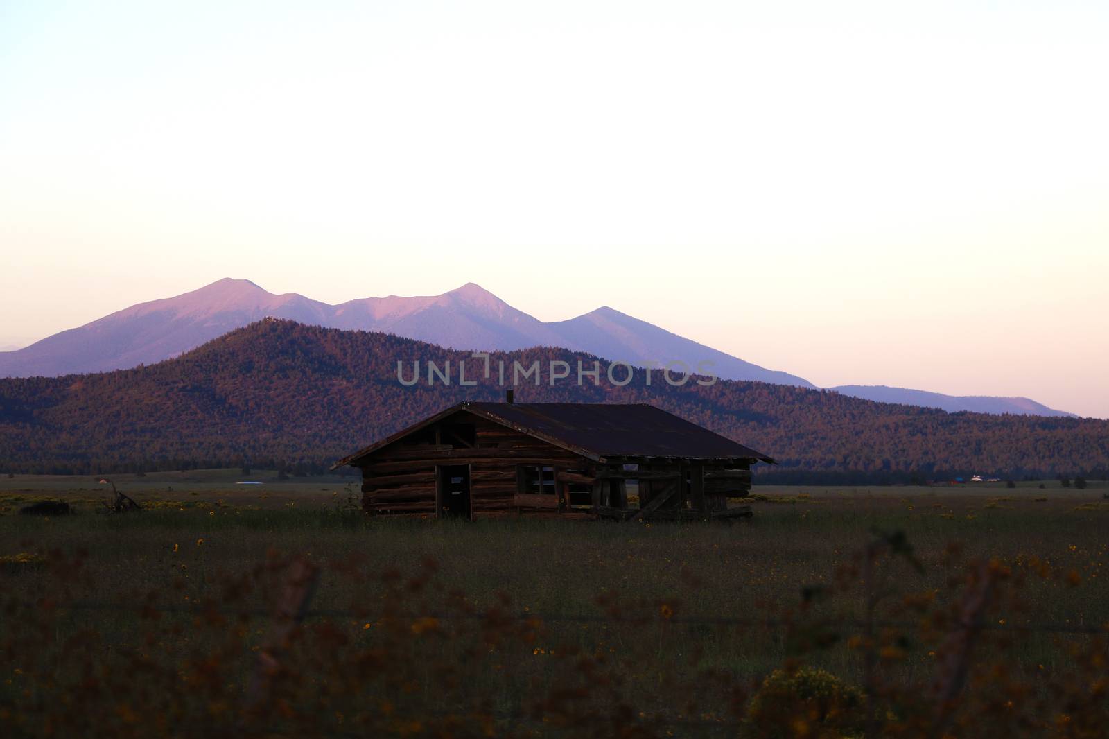 Old house in Arizona against the backdrop of the mountains during sunset. by kip02kas