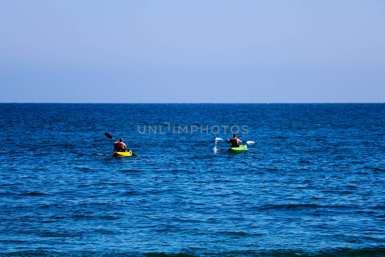 A pair of canoes in the Pacific. People kayak in the ocean. by kip02kas