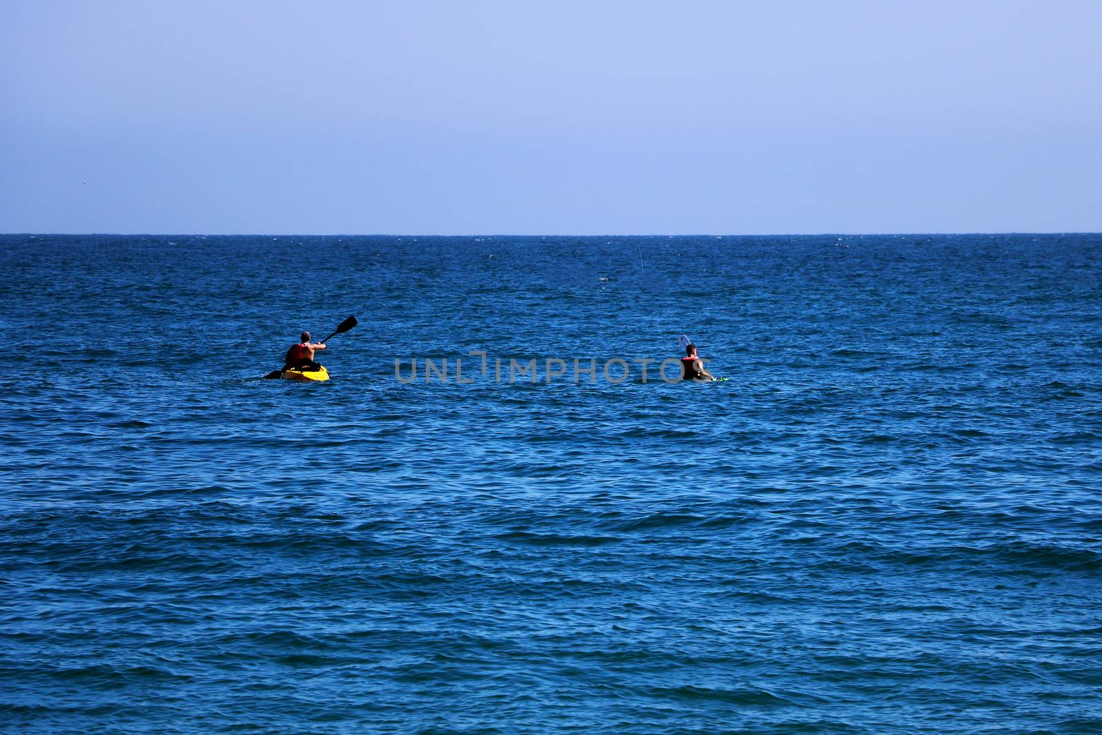 A couple of friends canoeing on a wooden canoe on a sunny day. USA