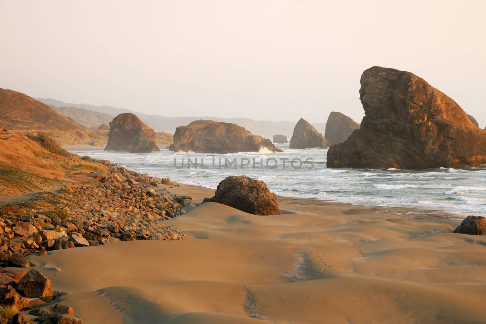 Sandy beach of the Pacific coast with rocks.