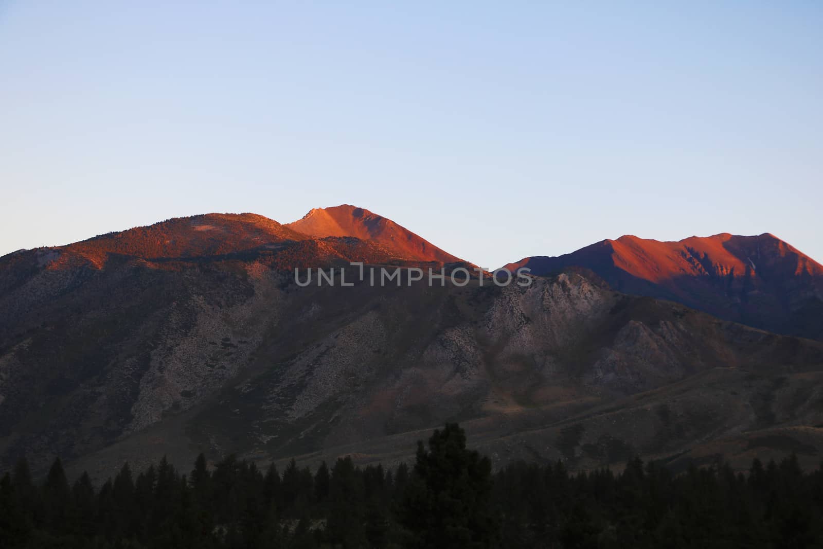 Rocks in the foreground and half dome in the distance during sunset at yosemite.