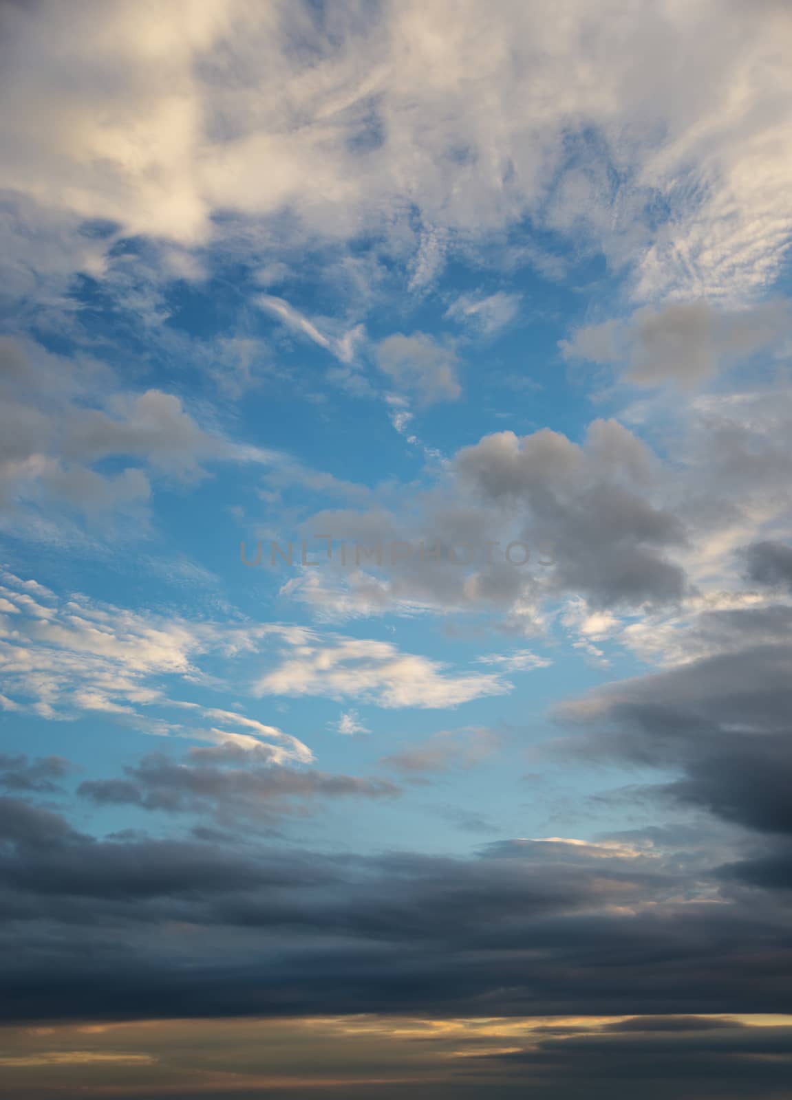 Beautiful dramatic sunset sky with dark clouds; vertical image