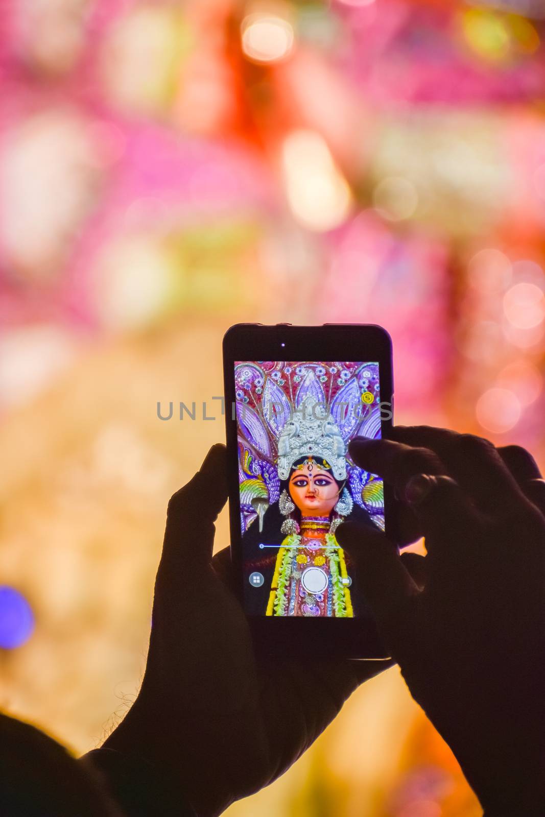Capturing photograph of Durga Idol with Mobile phone during durga puja festival in kolkata.