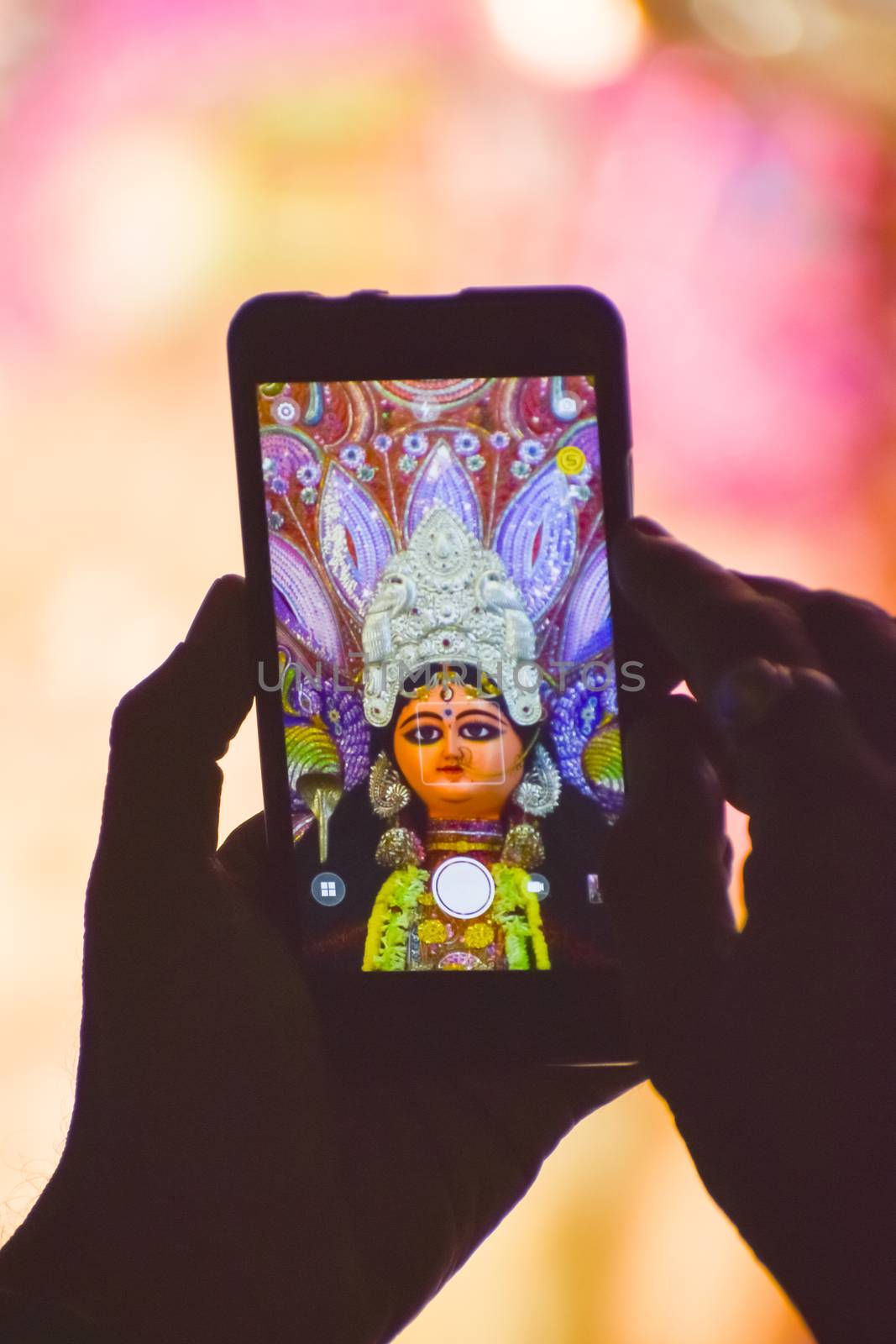 Capturing photograph of Durga Idol with Mobile phone during durga puja festival in kolkata. by sudiptabhowmick