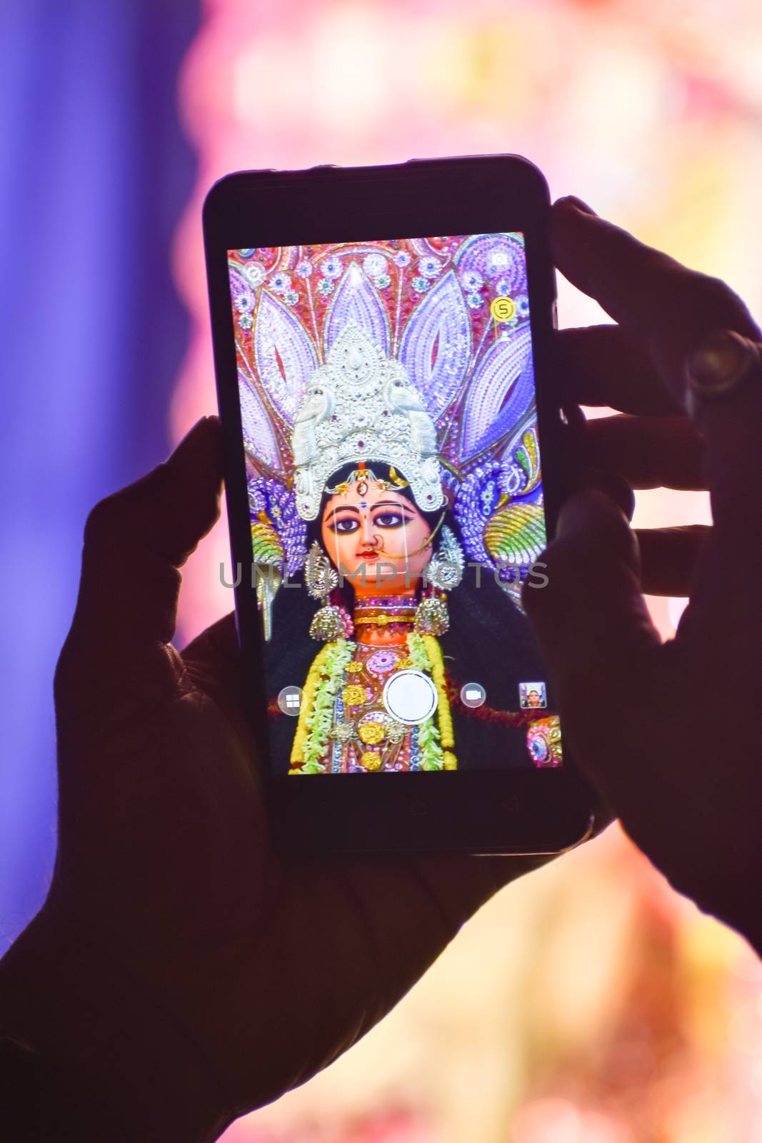 Capturing photograph of Durga Idol with Mobile phone during durga puja festival in kolkata. by sudiptabhowmick