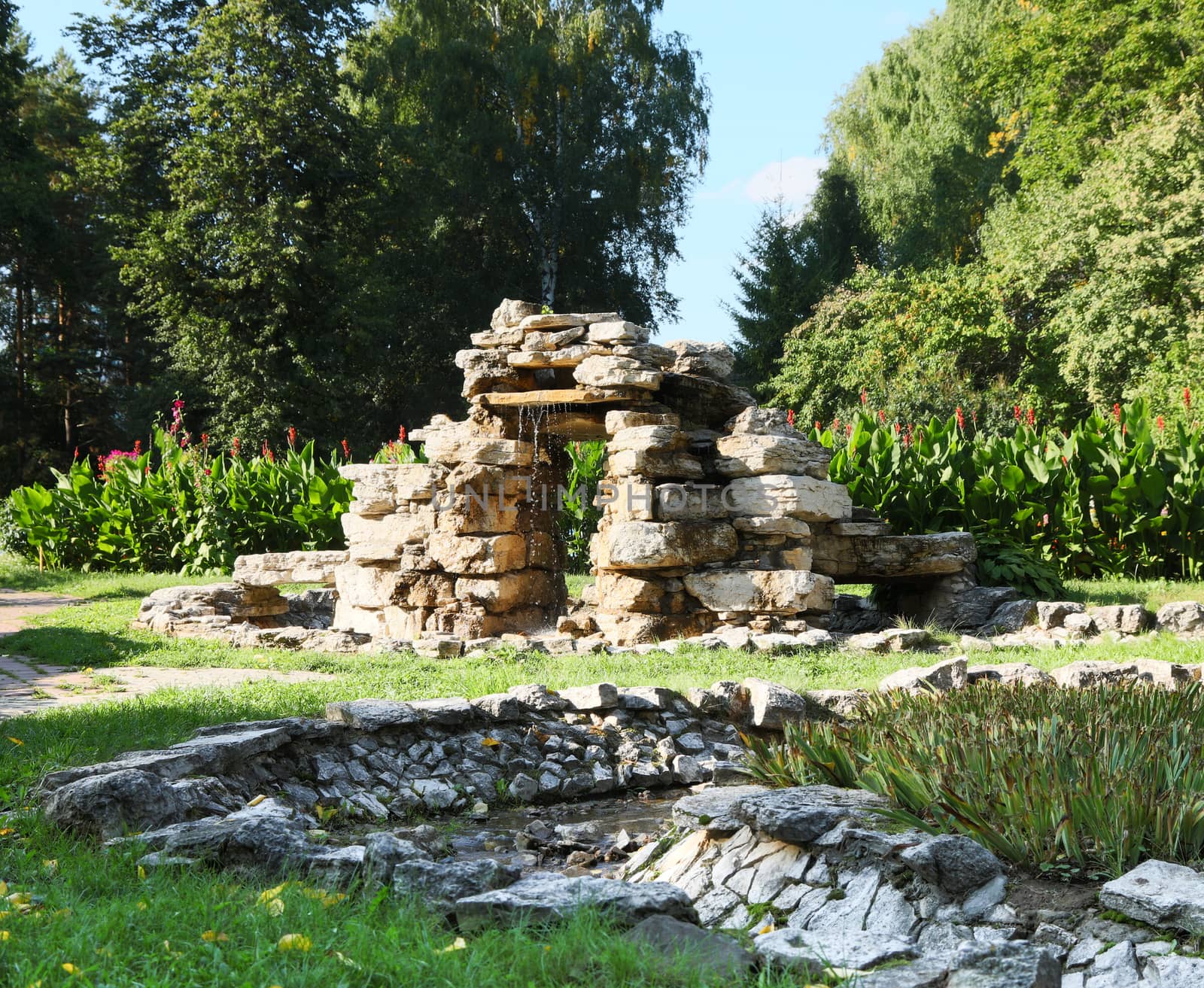 Beautiful man-made falls from a stone made the person in a garden.