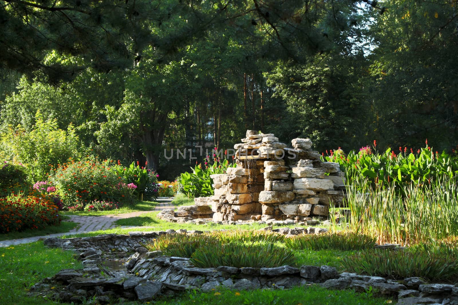 Beautiful man-made falls from a stone made the person in a garden.