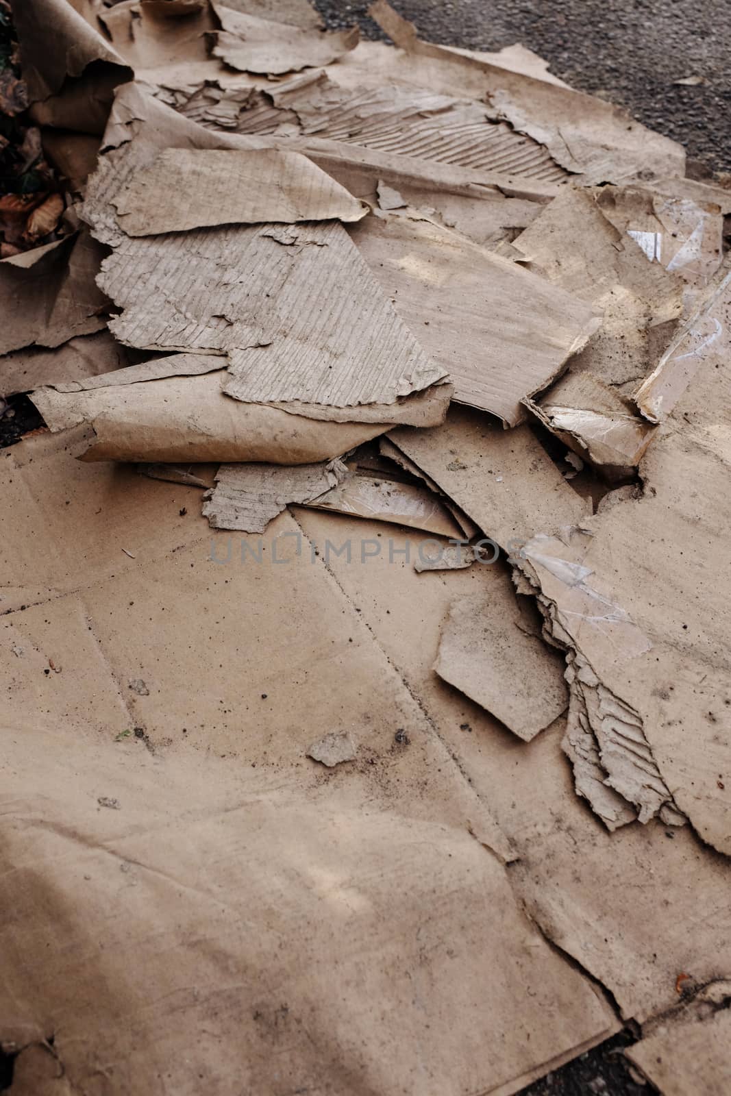 Dumped, dirty and ripped corrugated cardboard on a pavement; fly-tipping