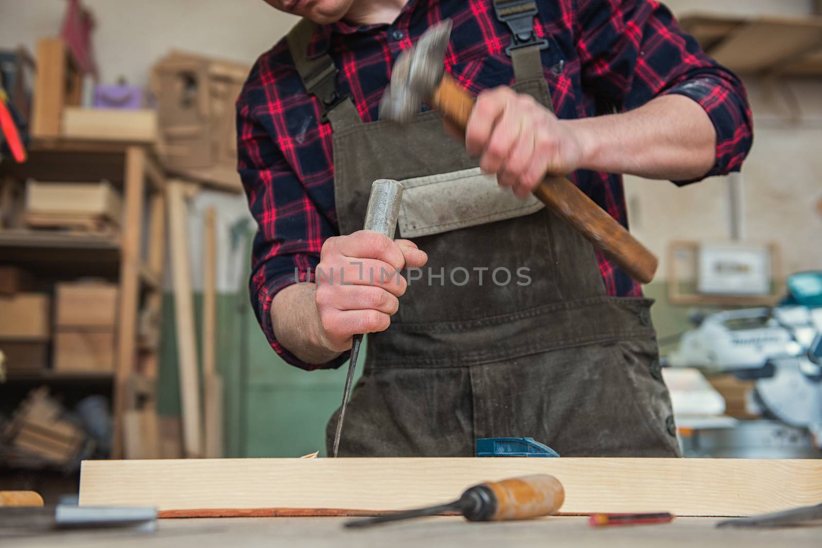 Carpenter worker cutting wooden board with circular saw. Profession, carpentry and woodwork concept.