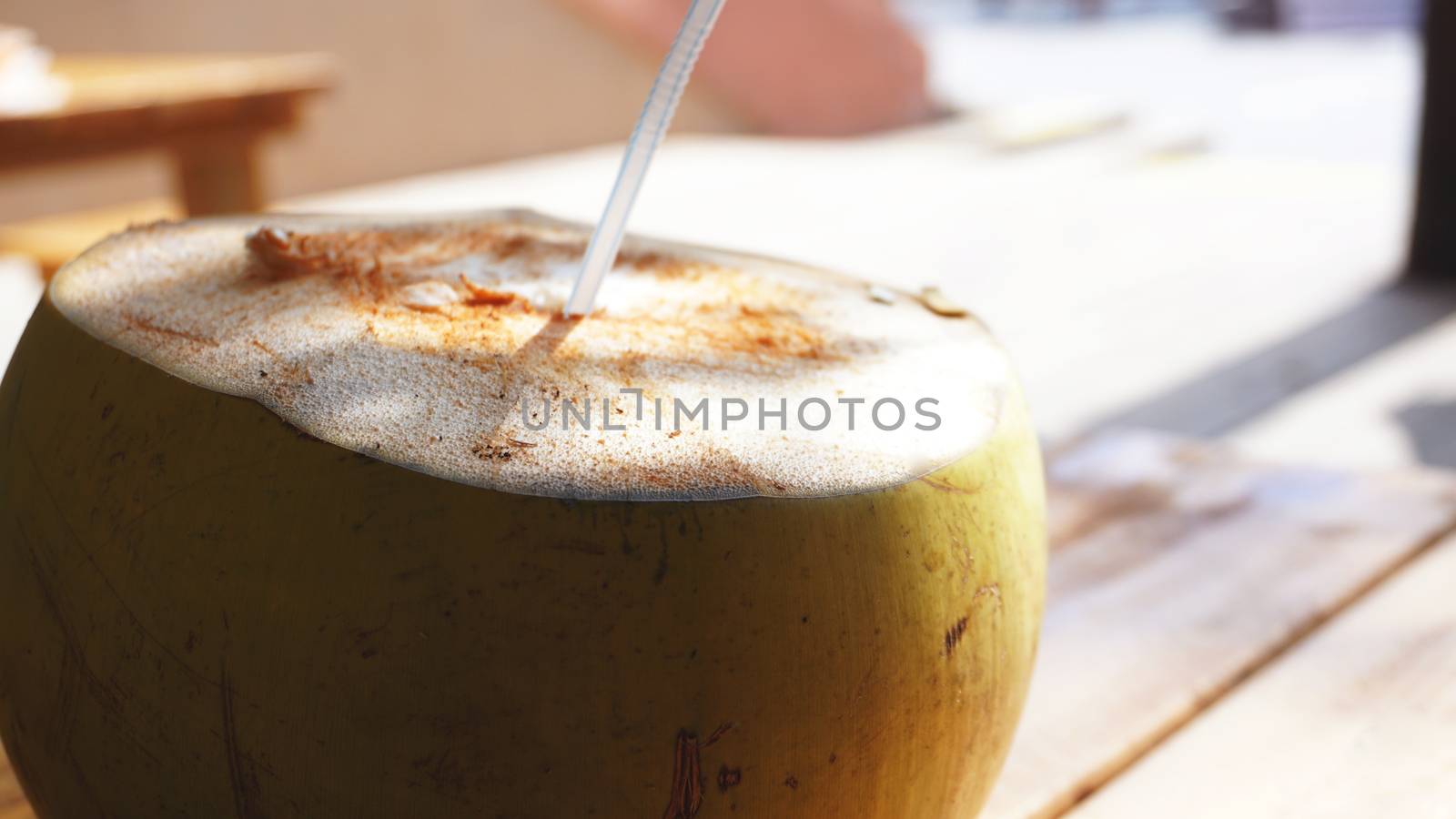 Coconut Water Drink on table with blurry background. Beach cafe, travel and relax