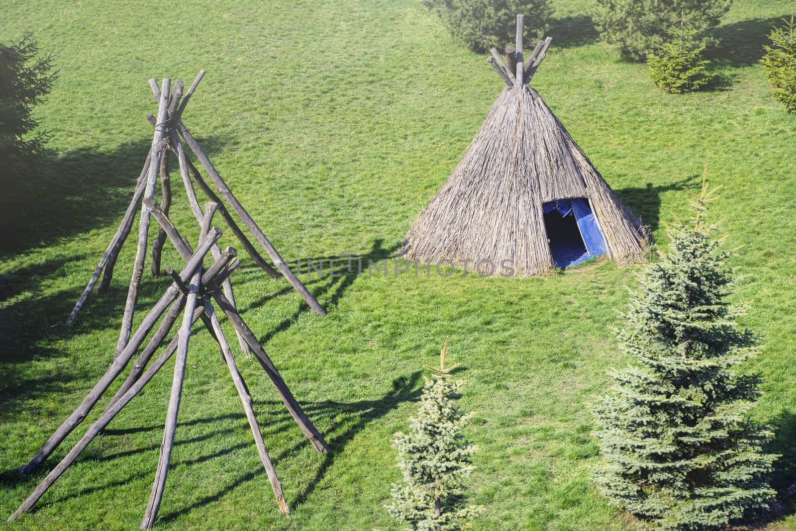 Wigwam type thatch huts .Straw wigwam on a glade on a sunny spring day.