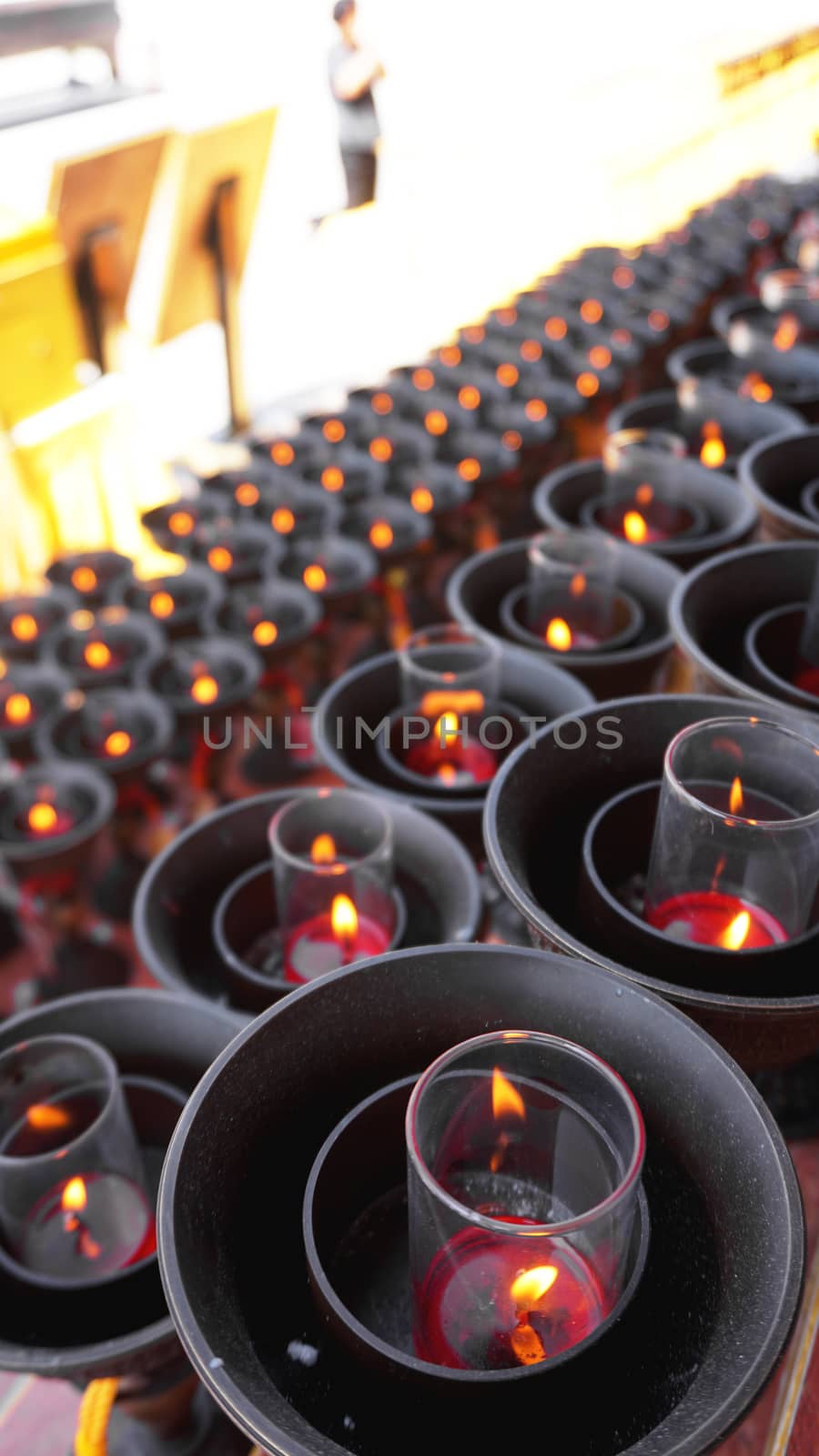 Burning big red candles in Buddhist temple by natali_brill