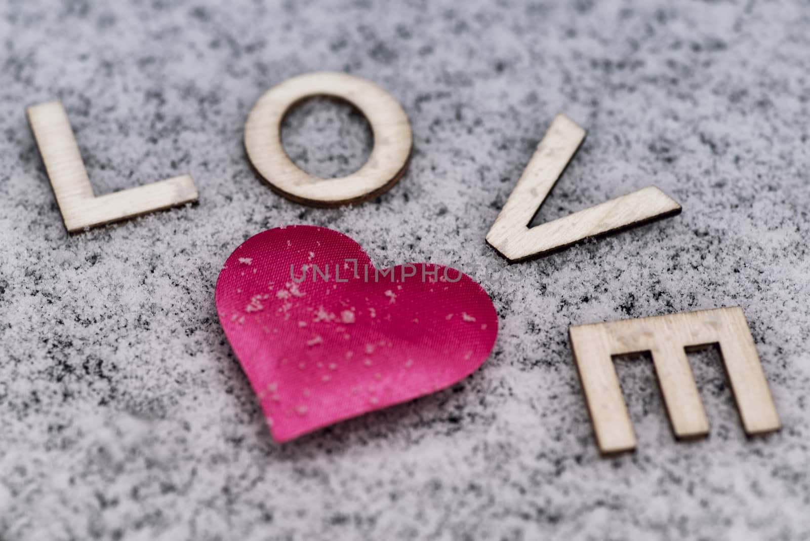 Valentine's Day. Heart of pink in the snow with the letters sweet. Valentine's Day. Soft focus. Background. Close-up.Heart drawn in the snow.