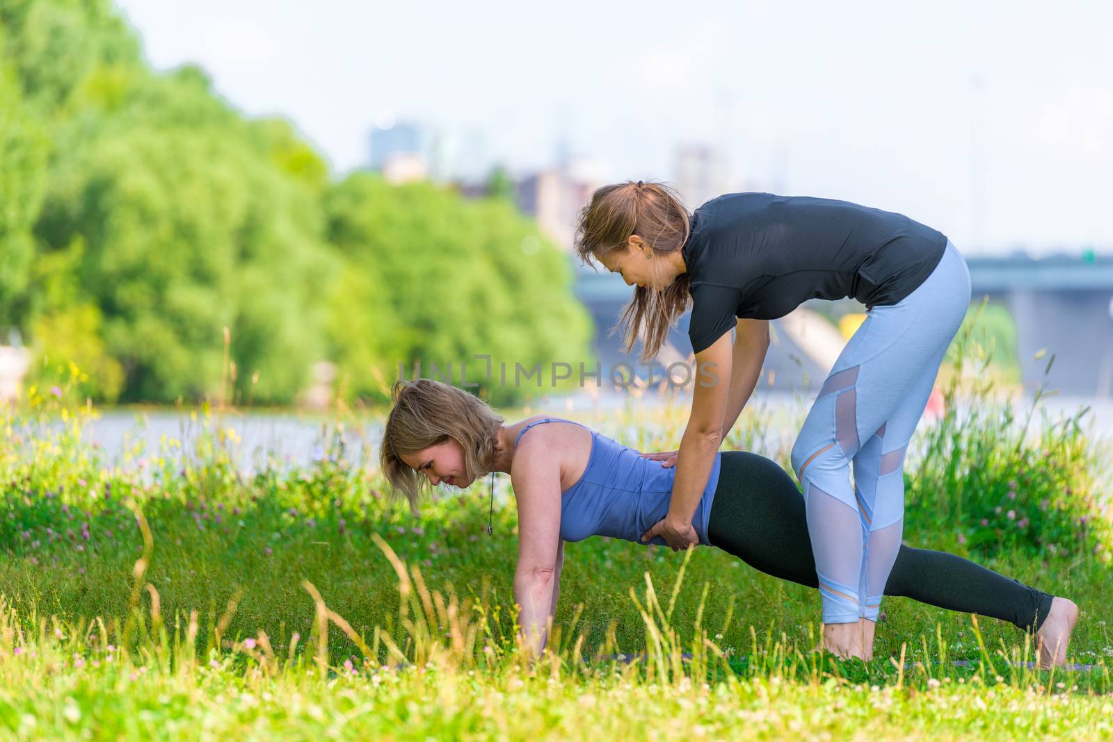 An experienced trainer practices yoga on an individual basis, outdoor sports in the park