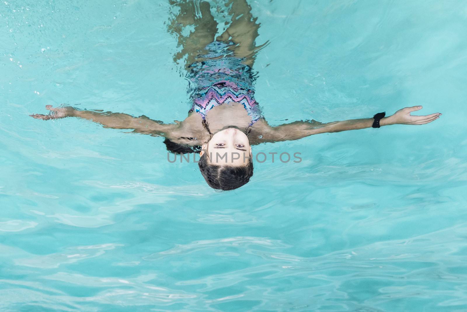 Beautiful girl swim and having fun in water.Active holiday.Girl swim in the pool. Happy girl play in the pool.