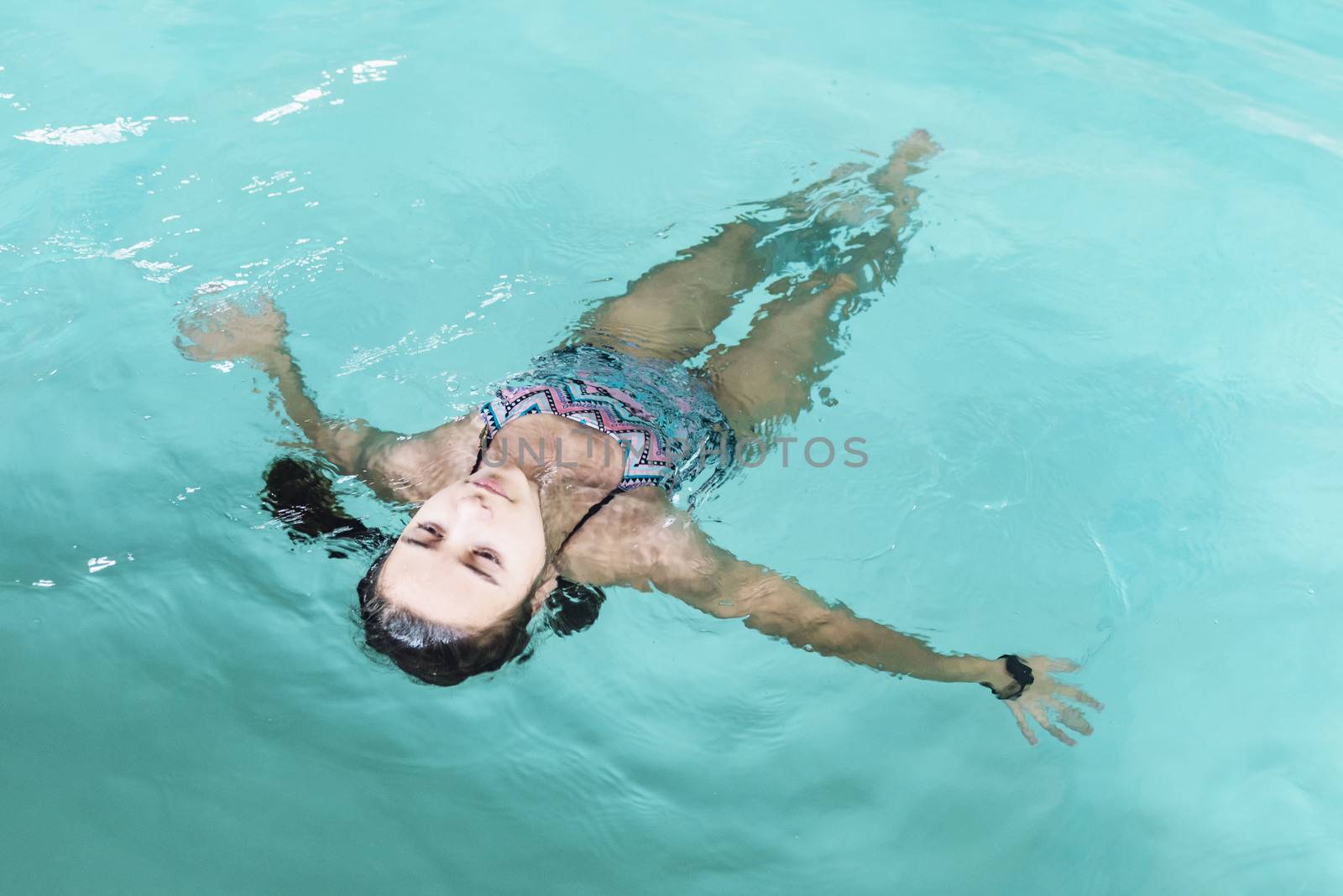 Beautiful girl swim and having fun in water.Active holiday.Girl swim in the pool. Happy girl play in the pool.