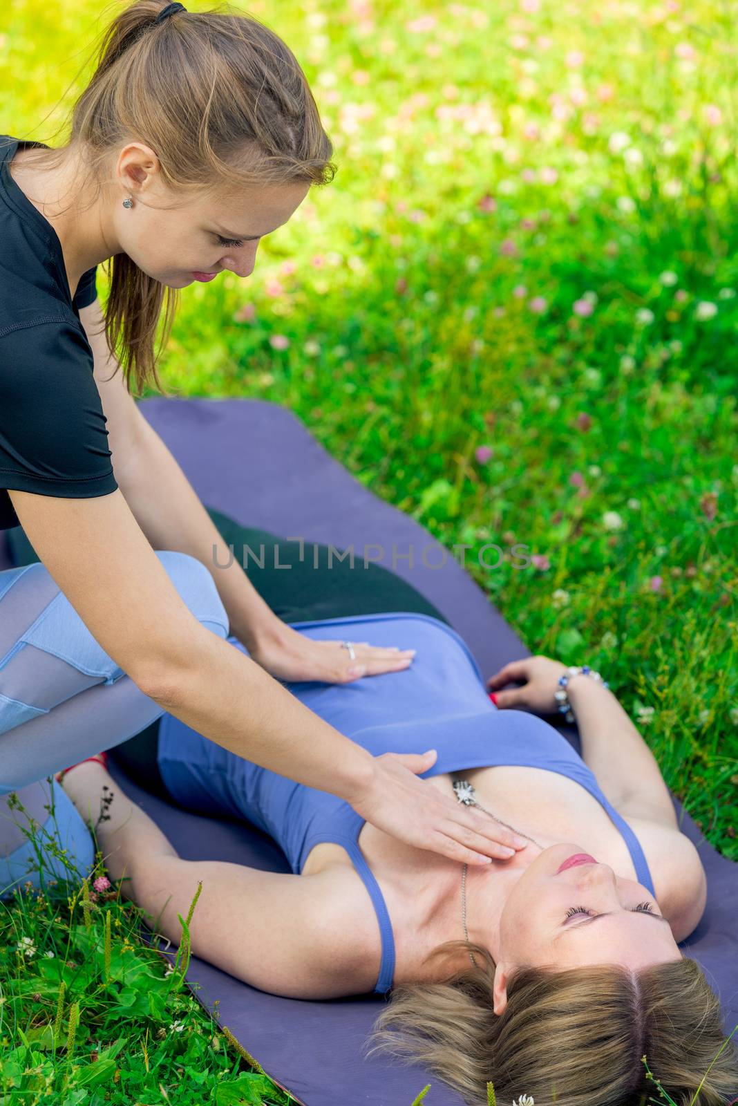 the trainer controls the woman’s breathing during a yoga class by kosmsos111