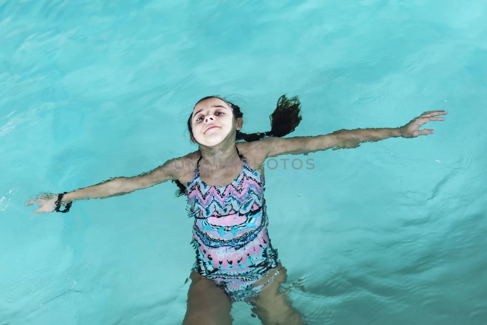 Beautiful girl swim and having fun in water.Active holiday.Girl swim in the pool. Happy girl play in the pool.