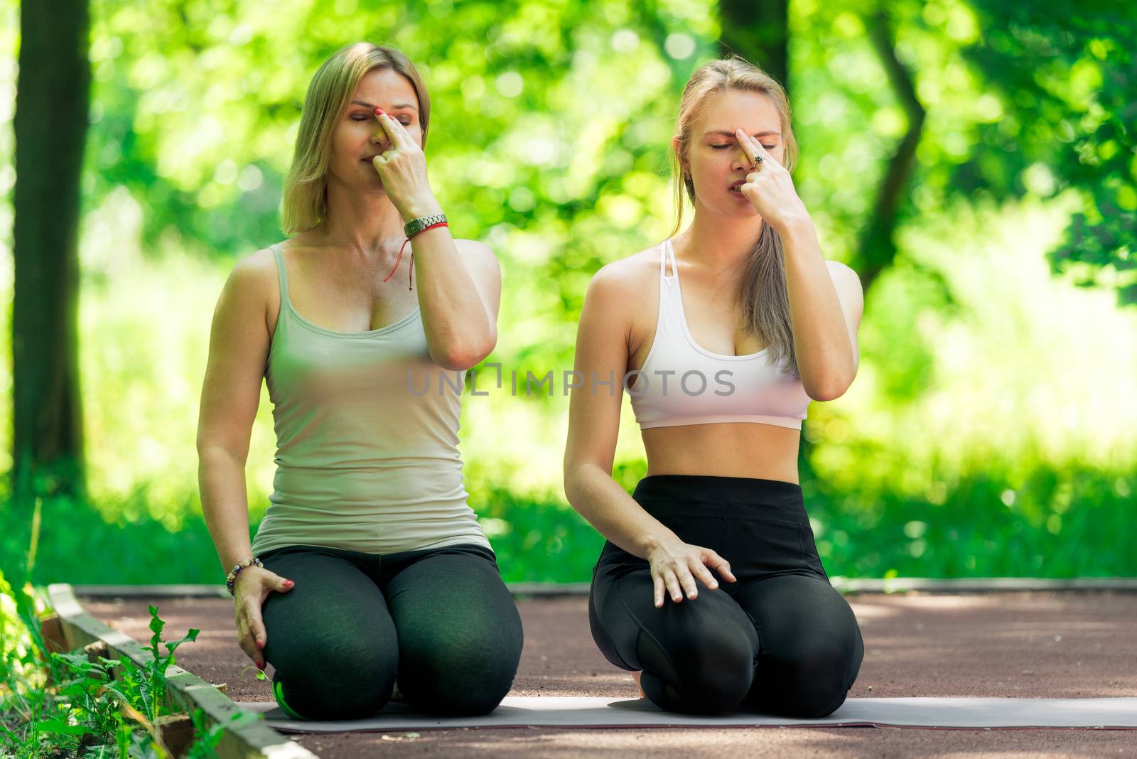 Woman 40 years old with a trainer perform breathing exercises with a trainer in the open air