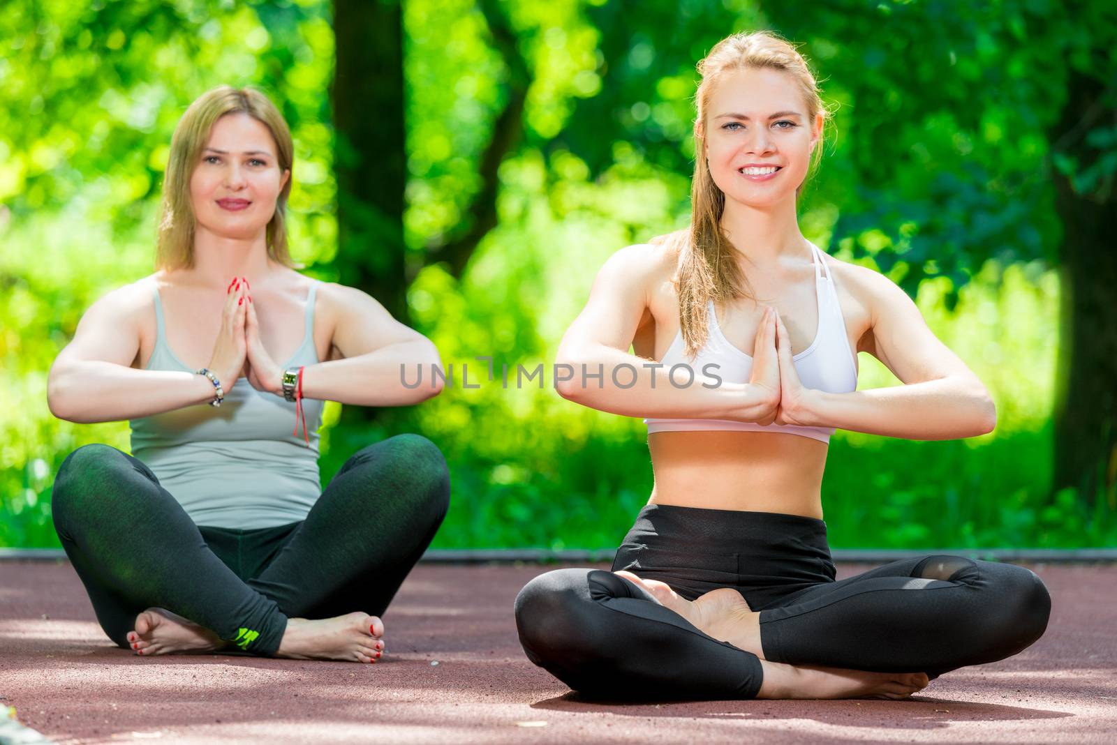 healthy lifestyle women doing yoga in the park in the lotus posi by kosmsos111