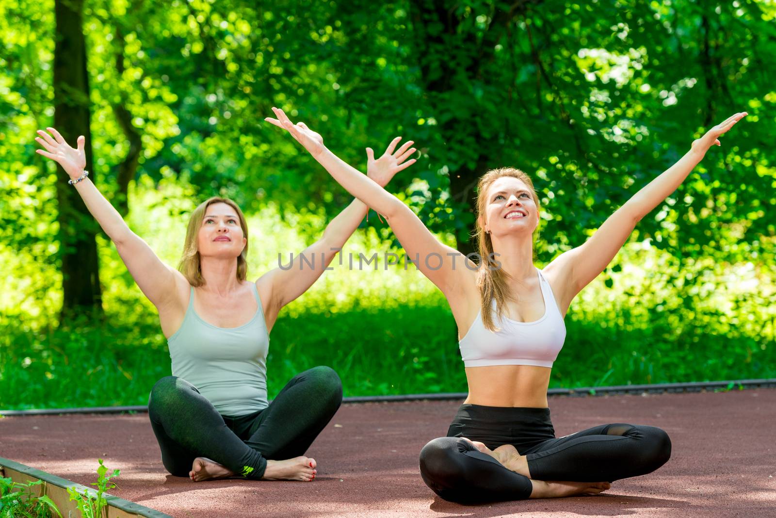 happy active women outdoors in lotus position doing yoga by kosmsos111