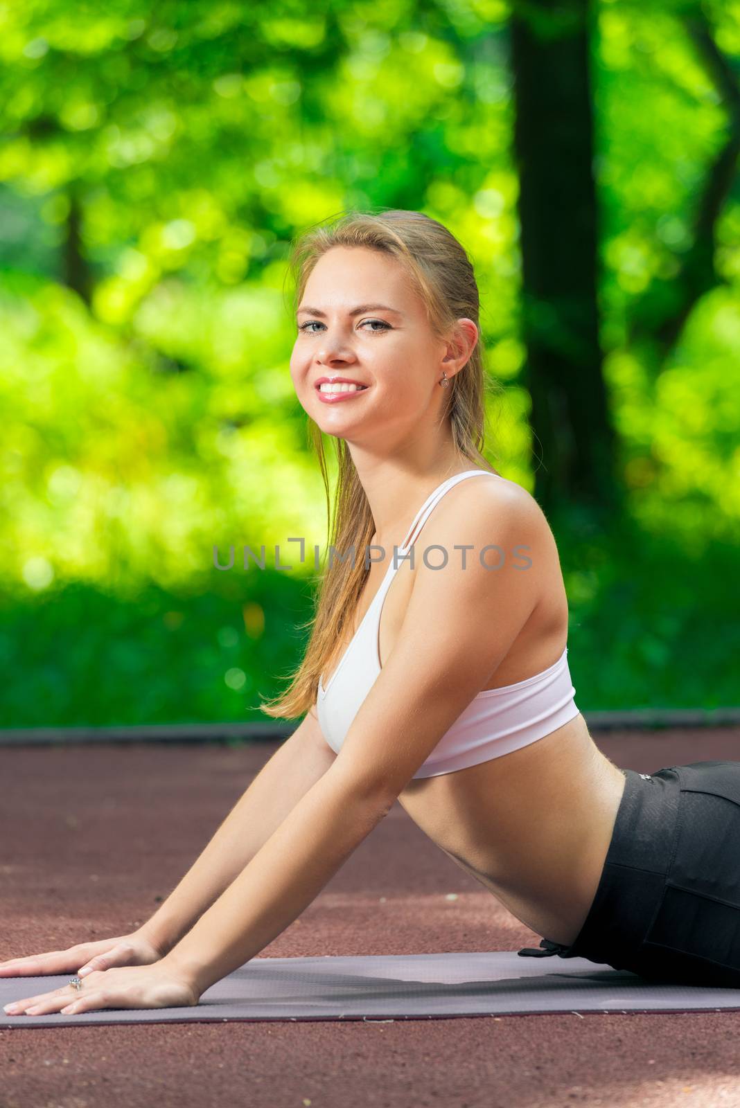 woman doing stretching exercises in the park in the fresh air by kosmsos111